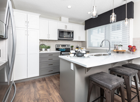 Edmonton townhouse for rent - a kitchen with white cabinets and a white counter top