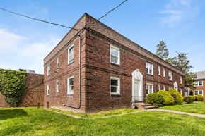 Philadelphia apartment for rent - a red brick house with a white door and a green lawn