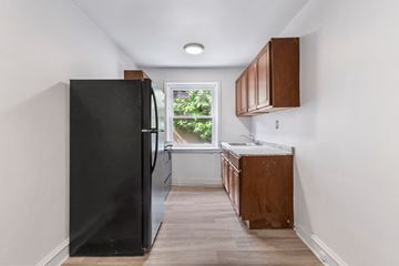 Philadelphia apartment for rent - a kitchen with a black refrigerator and wooden cabinets