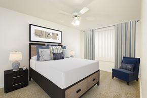 Rantoul apartment for rent - a bedroom with a large bed and a ceiling fan