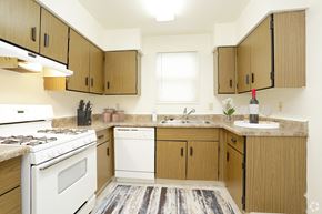 Rantoul apartment for rent - a kitchen with white appliances and wooden cabinets