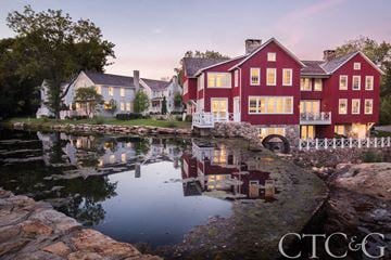 New Canaan apartment for rent - A red house is reflected in the water in front of it.