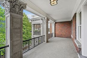 Kansas City apartment for rent - a long balcony with a brick building and a large window