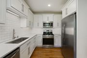 Kansas City apartment for rent - an empty kitchen with white cabinets and stainless steel appliances