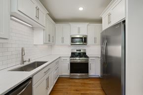 Kansas City apartment for rent - an empty kitchen with white cabinets and stainless steel appliances