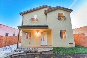 Los Angeles apartment for rent - A two-story house with a balcony on the second floor and a white door on the first floor.