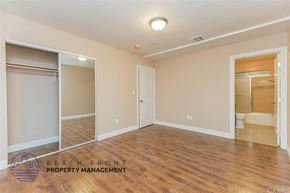 Los Angeles apartment for rent - A spacious room with wooden floors and a sliding door.