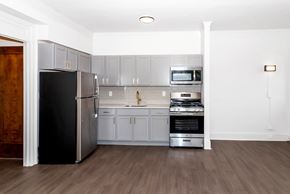 Minneapolis apartment for rent - A kitchen with a black refrigerator, stainless steel oven, and microwave.