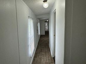 Aiken house for rent - A long, narrow hallway with a light on the ceiling and a door at the end.