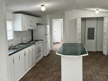 Aiken house for rent - A kitchen with white cabinets and a green table top.