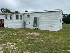 Aiken house for rent - A white building with a green door and windows.