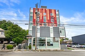 Seattle apartment for rent - a tall building with red and green facade on a city street