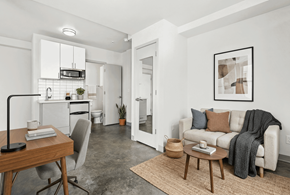 Seattle apartment for rent - A modern living room with a grey couch, a wooden table, and a rug.