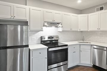 Oak Park apartment for rent - A modern kitchen with white cabinets and stainless steel appliances.