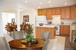 Hagerstown apartment for rent - A kitchen with wooden cabinets and a dining table with chairs.