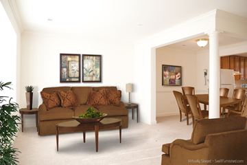 Hagerstown apartment for rent - A living room with a brown couch and a table with a plant on it.