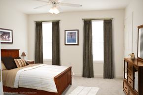 Hagerstown apartment for rent - A bedroom with a bed, dresser, and window with curtains.