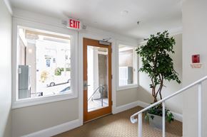 San Francisco apartment for rent - A hallway with a red exit sign above the door.
