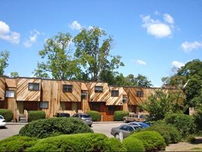 Ithaca apartment for rent - a large wooden building with cars parked in a parking lot
