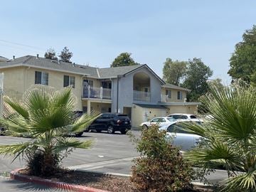 San Jose apartment for rent - an apartment building with a parking lot and palm trees