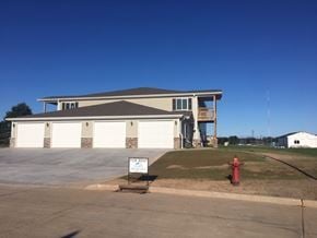 Manitowoc apartment for rent - A two-story house with a garage and a for rent sign in front.