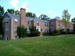 Ithaca apartment for rent - a large brick apartment building with a green lawn