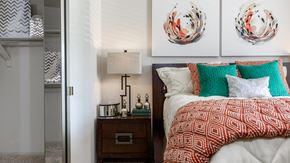 Stow apartment for rent - a bedroom with a bed with red and green pillows and a nightstand with