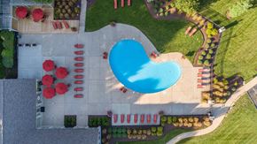 Stow apartment for rent - arial view of a swimming pool in a yard with umbrellas