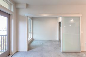 Seattle apartment for rent - an empty living room with white walls and a sliding glass door
