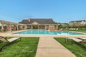 Cranberry Township apartment for rent - a swimming pool with lounge chairs and a house in the background