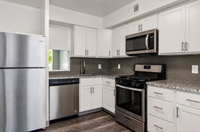 Pittsburgh townhouse for rent - A kitchen with white cabinets and a black microwave above the stove.