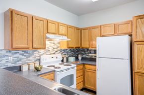 Memphis apartment for rent - a kitchen with wooden cabinets and a white refrigerator