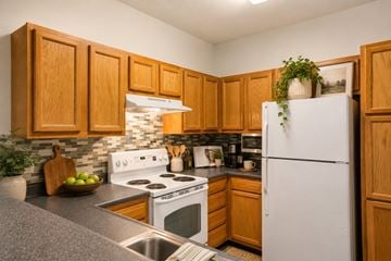 Memphis apartment for rent - A kitchen with wooden cabinets and a white refrigerator.
