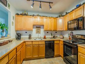 Dover apartment for rent - a kitchen with wooden cabinets and black appliances