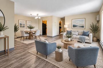 Pittsburgh apartment for rent - A living room with a grey sofa, a white table, and a painting on the wall.