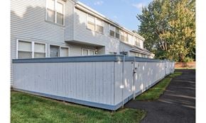 Rochester townhouse for rent - A long white fence runs along the side of a building.