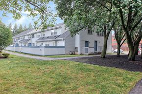 Rochester townhouse for rent - exterior of apartments with trees and green space