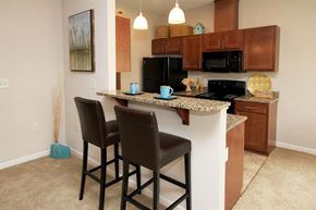 Watertown apartment for rent - A kitchen with brown chairs and a granite counter.