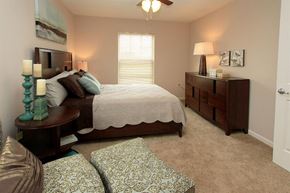 Watertown apartment for rent - A bedroom with a bed, nightstand, and a chair.