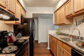Camillus apartment for rent - a kitchen with black appliances and wooden cabinets