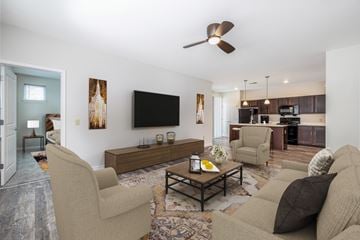 Orchard Park townhouse for rent - A living room with a brown couch and a black television.
