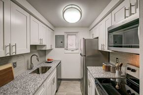 Tonawanda apartment for rent - A kitchen with white cabinets and a black stove top.