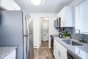 Brockport townhouse for rent - kitchen with white cabinets, granite counters, and stainless appliances
