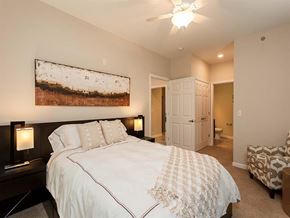 Canonsburg apartment for rent - A bedroom with a large bed and a painting on the wall.