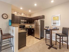 Canonsburg apartment for rent - A kitchen with a refrigerator, a microwave, a stove, and a clock on the wall.