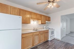 Pittsford apartment for rent - A kitchen with wooden cabinets and a white fridge.