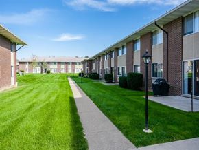 Webster apartment for rent - A long grassy area in front of a building with a walkway.
