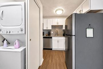 Webster apartment for rent - A white oven and dishwasher are in a kitchen with wooden floors.