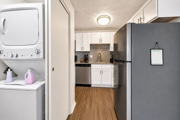 Webster apartment for rent - A white oven and dishwasher are in a kitchen with wooden floors.