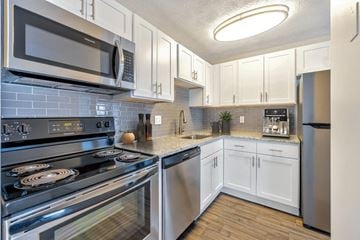 Webster apartment for rent - A kitchen with white cabinets and stainless steel appliances.
